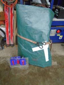 lot 107 image: Heavy duty tarp. Approx. 45 x 25. Has a couple tears that have been taped. As shown.