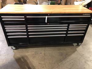 lot 31 image: Husky 72 in. W x 24 in. D Standard Duty 18-Drawer Mobile Workbench Tool Chest with Solid Wood Top in Gloss Black Customer Returns See Pictures