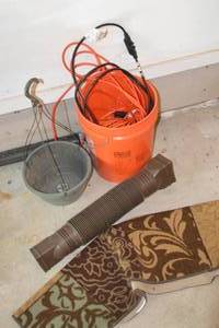 lot 206 image: Bucket with extension chords, hanging planter, gutter drain tube, and doormat