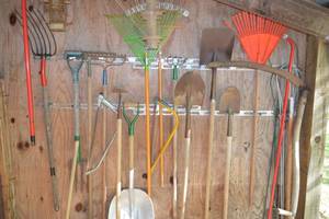 lot 215 image: Rack of shovels, rakes, various other tools - see pictures