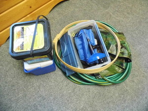 lot 331 image: Handyman lot including a garden hose, drain snake, cooler partial tub of roof melt and more