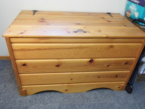 lot 351 image: Solid wood storage box filled with quilts and bed spreads