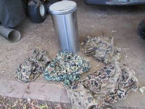 lot 492 image: Stainless steel garbage can with an assortment of camo burlap and netting