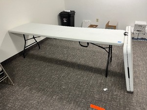 lot 1614 image: (2) White Folding Tables with easy-to-carry handle. Measures 96 W X 30 D X 29 H.