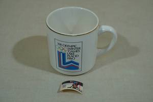 lot 131 image: 1980 Lake Placid Olympic Winter Games Miracle on Ice Collectors Mug and Stamp