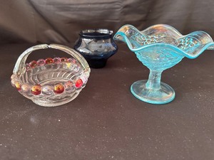 lot 140 image: Mid-Century Modern Vintage Glass Pieces Including Clear Molded Glass Basket with Cranberry Beaded Edge and Handle, Imperial Glass Blue Carnival Glass Compote, and Blue Depression Glass Bowl