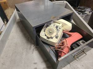 Collection of vintage phones and camera in steel drawer