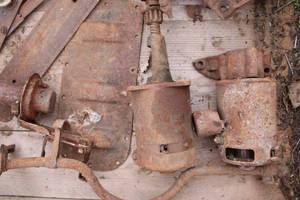 lot 108 image: Large wood box with Ford Model T parts, starter, generator, hogs head, drive shaft, misc.