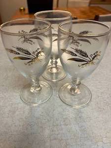 lot 10 image: Set of 3 gold rimmed mid sized glasses with leaf pattern