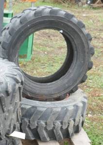 2 skid loader tires, one on a rim