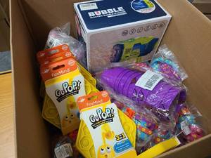 Box of various toys for kids, bubble blowers, popits, cups and squishy toys
