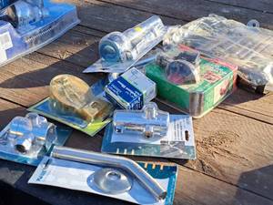 lot 480 image: Lot of (9) Misc. Plumbing Supplies and Parts (in original packaging) - Shower Arm, Hydrant Elbow, Flapper, Diverter, Pop-Up Drain Assembly, Shower Curtain