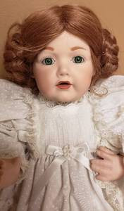 lot 162 image: Antique Bisque Doll in Cream Dress with Reddish Brown Real Hair