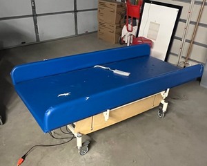 lot 43 image: MSRP $6000 Bariatric 1000lb Capacity Patient Power UpDown Examination Changing Table With Remote And Drop Down Side Rails - Great Working Condition - Upholstery Has Tears