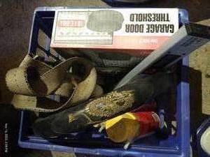 lot 595 image: Crate With Digital Angle Finder, New Garage Door Threshold, Spray Foam, Tie Down Strap, And Other Misc.
