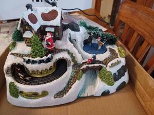 lot 52 image: Box of Christmas Decorative Items A Plastic Christmas Village on a Mountain with Train and Ice Skaters Powered by 3 AA Batteries