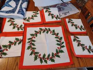 lot 56 image: Two Holiday Table Runners and a Set of Six Cloth Napkins, and a Merry Christmas Wall Hanging, The Large Red Table Runner is 70-inches