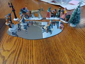 lot 64 image: Ceramic Christmas Village Pieces with an Ice Skating Pond, People, Trees, and Accessories, (Street Sign has a Broken Part)