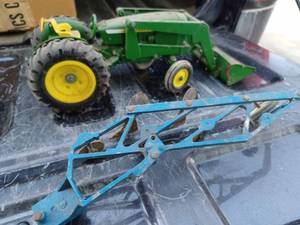 lot 54 image: Ertl 116th Scale John Deere Utility Tractor with Loader and a Ford 4-Bottom Plow with 2-Moldboards Broken Off, Both are Sandbox Toys