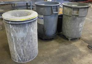 3 garbage barrels and a wastebasket