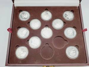 lot 17 image: (11) Proof 1 Troy Ounce Silver Grand Slam Rounds in Wood Display Case.