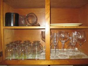 All glass mugs, stemware and other glassware in upper cupboards right of fridge.