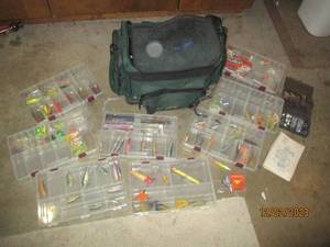 Soft sided Cabelas tackle box with multiple Plano compartmentalized Storage organizers containing an assortment of baits, lures and other fishing supplies and equipment