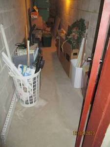 All content of lower corridor includes flooring transition, mini blinds, curtain rods, swiffer, trash can, laundry basket, vintage storage organizer, 3-drawer plastic organizer, vacuum cleaner, etc.