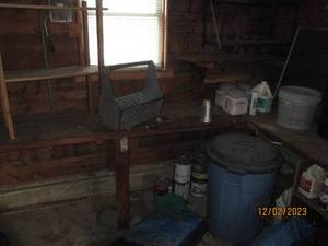 Corner lot of outdoor chemicals and supplies, landscaping mulch, lidded garbage can, 2 small shelving units and other supplies
