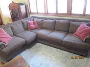 Large 2pc Brown Upholstered Sectional Sofa with with nail-head accents on each ends arm rest and 3-accent pillows. Each section measures approximately 76 long.