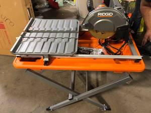 lot 31 image: RIDGID 9 Amp 7 in. Blade Corded Wet Tile Saw with Stand Customer Returns See Pictures
