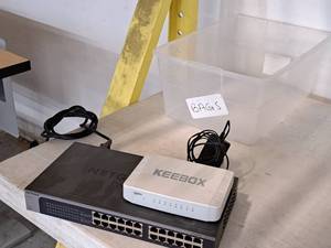 lot 217 image: Lot of (2) Computer Switches with Tote Bin - Keebox, Netgear ProSAFE Plus JGS524E