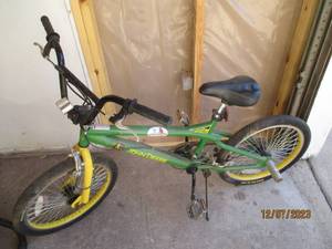 lot 9 image: Boys John Deere BMX style bike with rear foot pegs