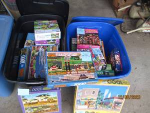 lot 50 image: (2) Covered Storage Totes filled with a nice assortment of jigsaw puzzles in a variety of difficulty levels. (If any pieced were to be missing, it seems to be noted)