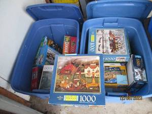 lot 51 image: Nice assortment of jigsaw puzzles in a variety of difficulty levels. (If any pieced were to be missing, it seems to be noted) filled between (2) covered storage totes