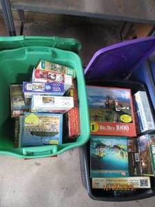 lot 56 image: Nice assortment of jigsaw puzzles in a variety of difficulty levels. (If any pieced were to be missing, it seems to be noted) filled between (2) covered storage totes