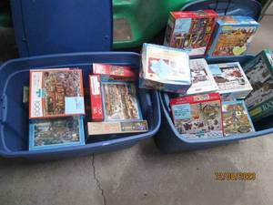 lot 61 image: Nice assortment of jigsaw puzzles in a variety of difficulty levels. (If any pieced were to be missing, it seems to be noted) filled between (2) covered storage totes