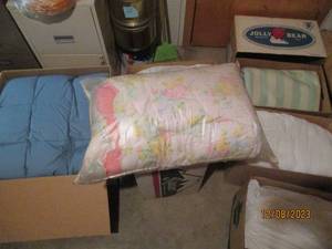 lot 29 image: Multiple boxes containing an assortment of blankets, mattress pads and other bedding supplies