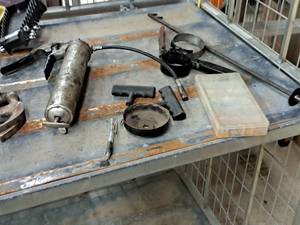 lot 889 image: Hand Tools - Grease Gun, Oil Filter Wrench, Axle Nut Cover Wrench, Container of Fuses, T-Handle Plugger, T-Handle Reamer, Grabber Tool