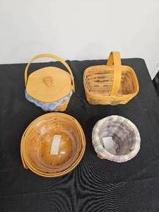lot 91 image: Assortment of Longaberger Baskets Inc. Tea Basket 1993 w Fixed handle - Protector, 2000 Frosty Jr. - Horizon of Hope - Cloth Liner and Plastic Protector INC, 1994 - Small spoon basket - Protector and liner INC