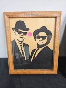 lot 38 image: Wall Art Pete ODonnell Framed Wood Cut Face Silhouettes of the Blues Brothers, Prince & Einstein