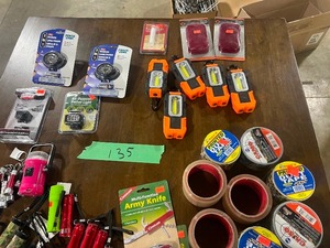 lot 135 image: TABLE FULL OF FLASHLIGHTS, TAPE, KNIVES, & HAND WARMERS