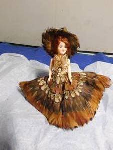 lot 280 image: Vintage doll with feather clothing