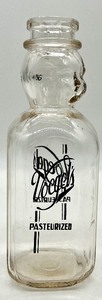 lot 143 image: Vintage Unique VOEGELS PASTEURIZED Quart Liquid IT WHIPS Bottle with FACE and Cream Top Spoon from 1920s