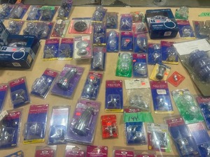 TABLE FULL OF FIXTURE HANDLES, FIXTURES, AND DISCHARGE KITS