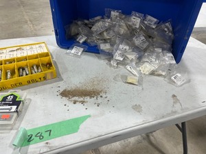 TABLE FULL OF SHOULDER BOLTS, PLASTIC SPACERS, & CROSS DOWELS