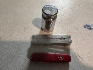 lot 318 image: Swiss Army Knife, Multi Tool, and Scale Calibration Weight
