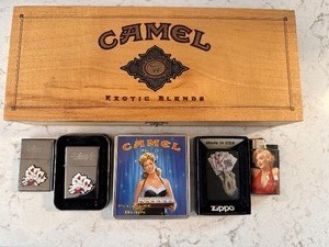 lot 208 image: Zippo Dead Mans Hand Design Flip Top Lighter, Two Zippo Sailor Jerry 2007 Black Midnight Limited Edition Lighters, Camel Exotic Blends Pine Box, Camel Girl 1990s Vintage Cigarette Holder, and Vintage Marilyn Monroe Lighter