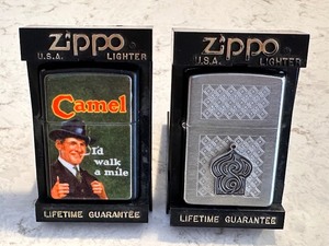 lot 210 image: 1997 Zippo Camel Id Walk a Mile Flip Top Lighter and 2000 Zippo Silver Camel Pleasures of the Casbah Pewter Mosque Lighter