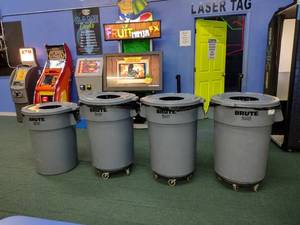 lot 142 image: (4) Brute 44-gallon Covered Utility Containers, 3 are on wheels.